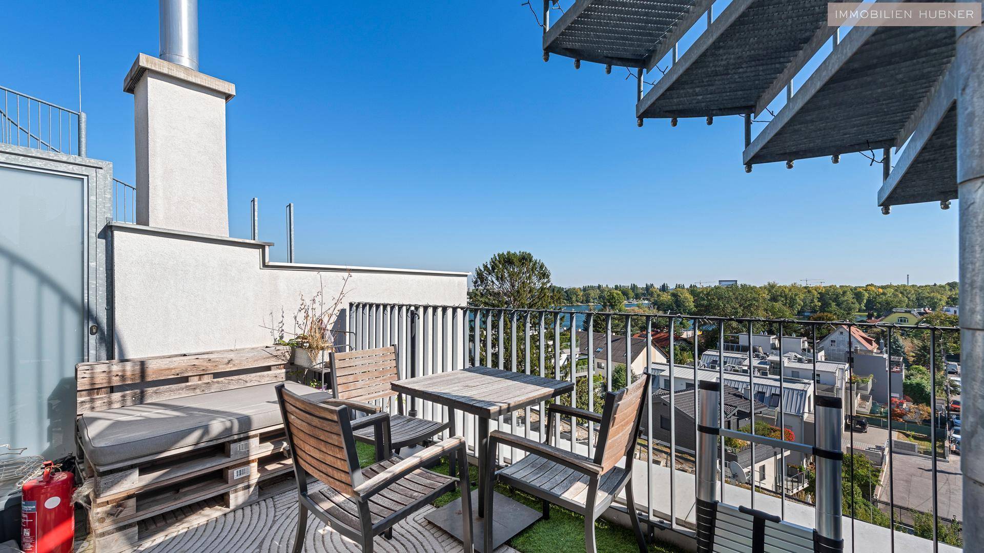 Kleiner Balkon mit Holzbänken und Tisch, ideal für entspannte Stunden im Freien.