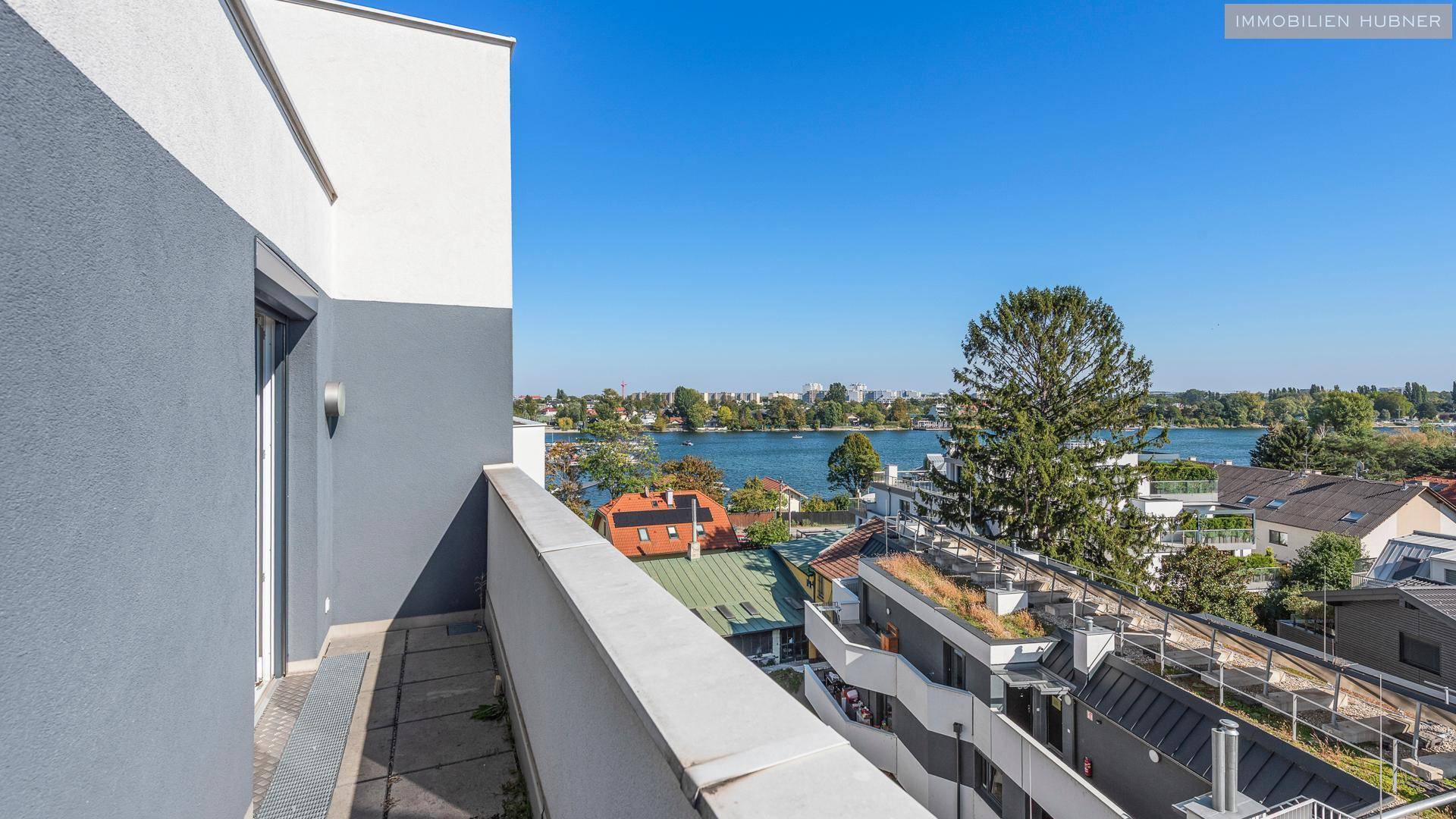 Schmaler Balkon mit Blick auf den See und die umliegende Wohngegend.