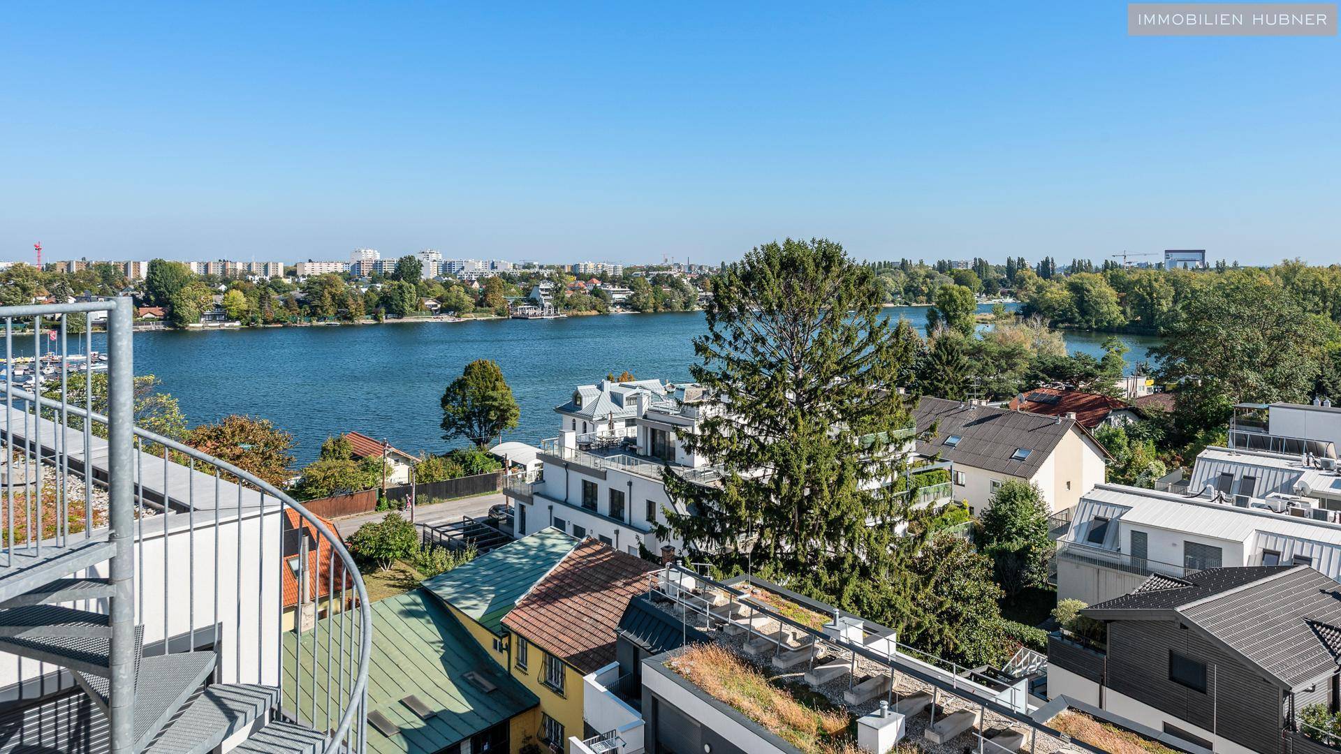 Malerischer Blick auf den See und die umliegende Wohnbebauung mit viel Grün.