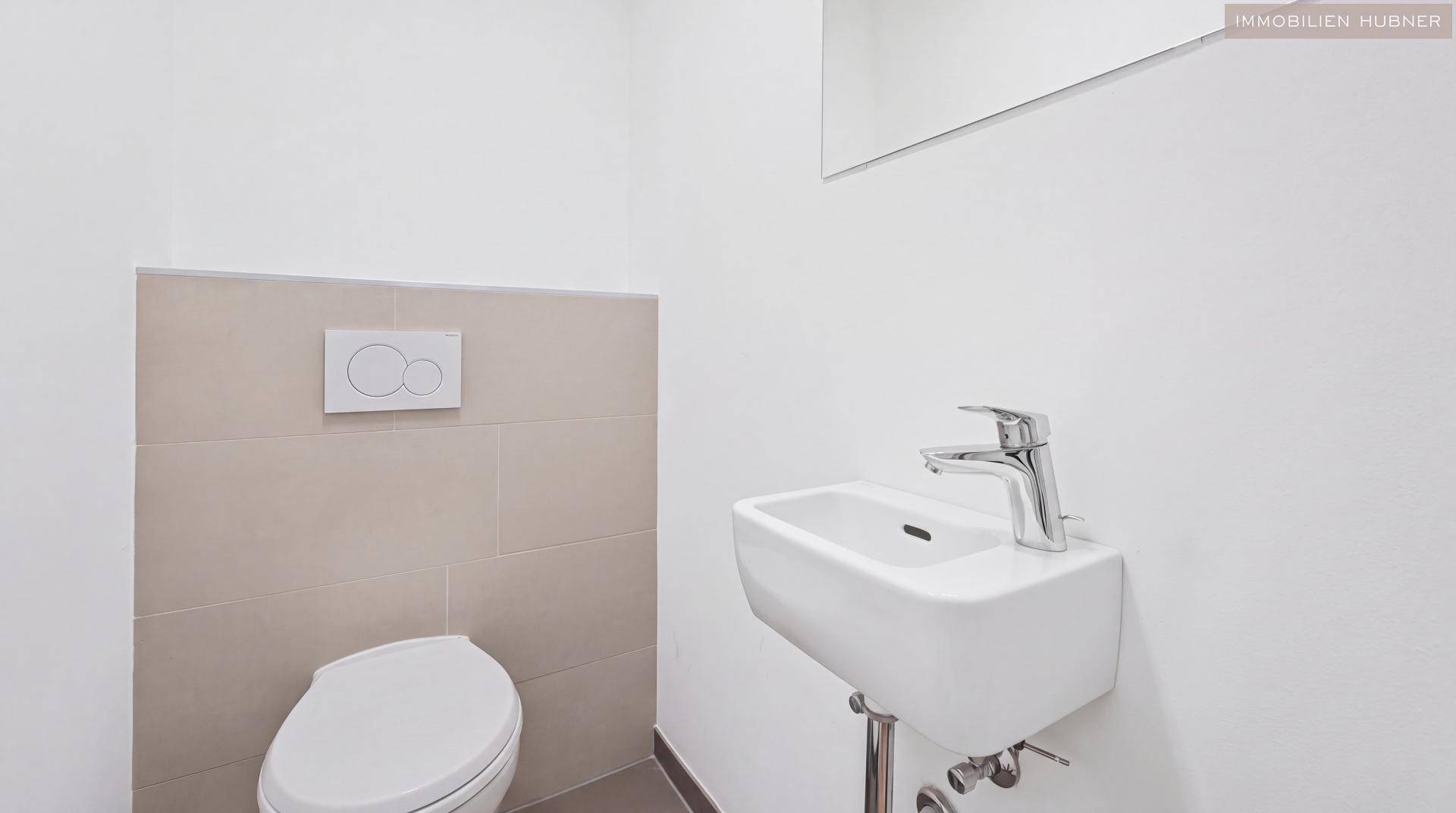 Kleines Gäste-WC mit wandhängendem WC und modernem Waschbecken.
