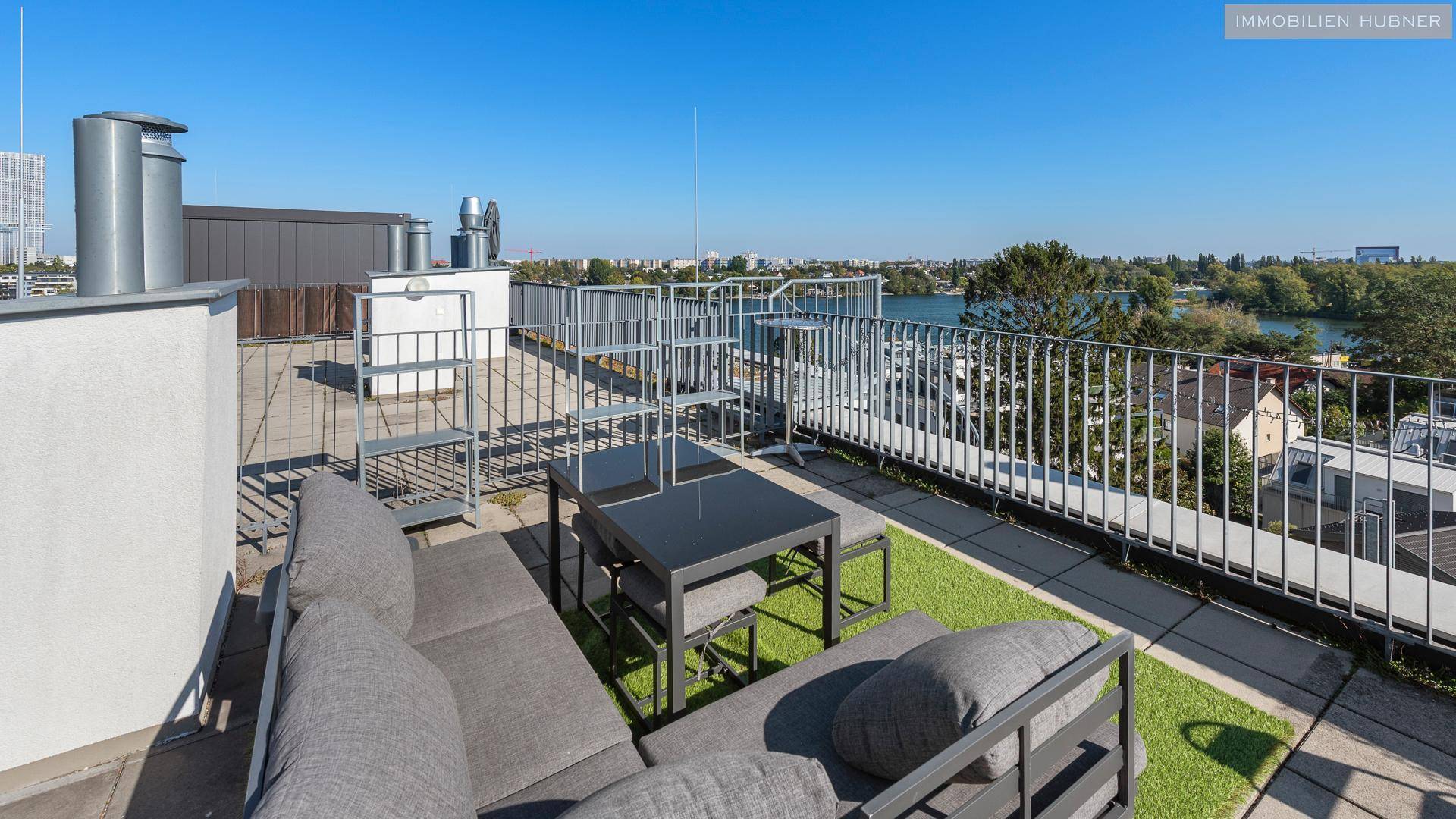 Gemütliche Dachterrasse mit Lounge-Bereich und weitem Blick auf den See und die Umgebung.