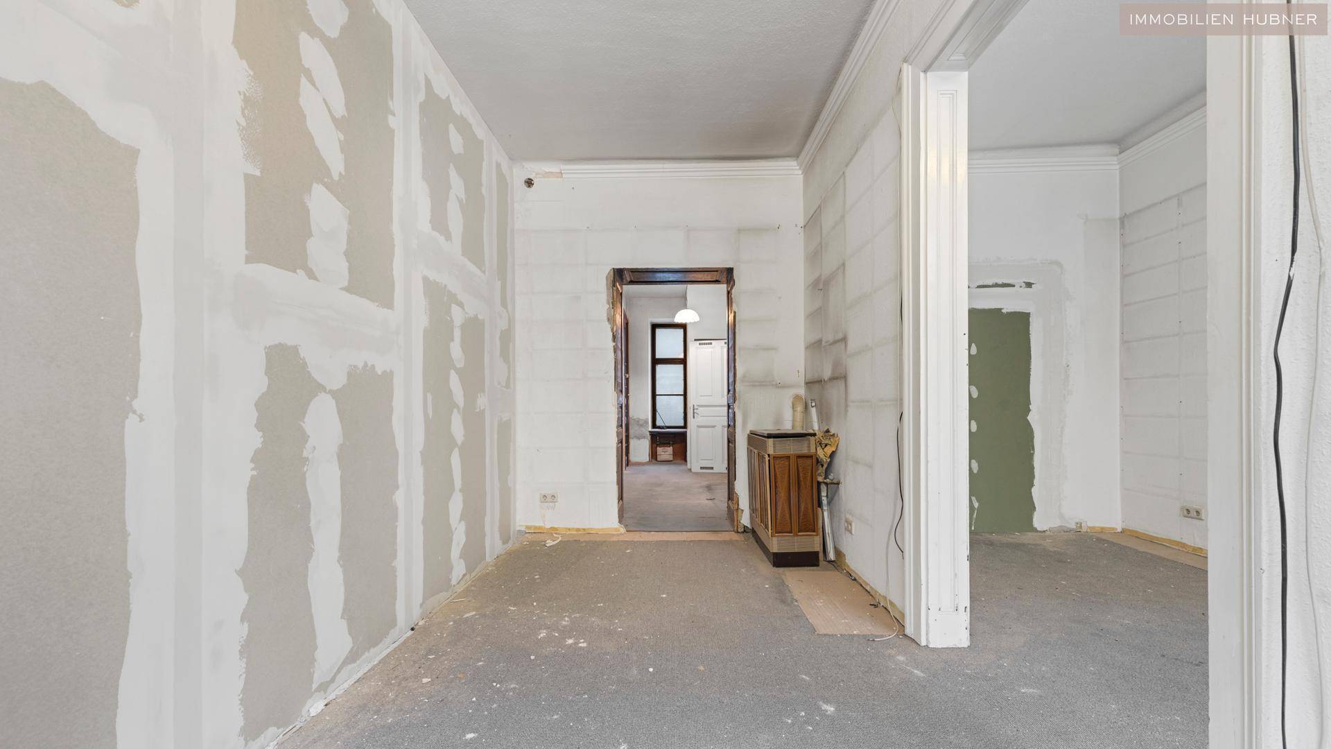 Unmöblierter Raum in Renovierung mit mehreren Türöffnungen und vorbereiteten Wänden für den Ausbau.