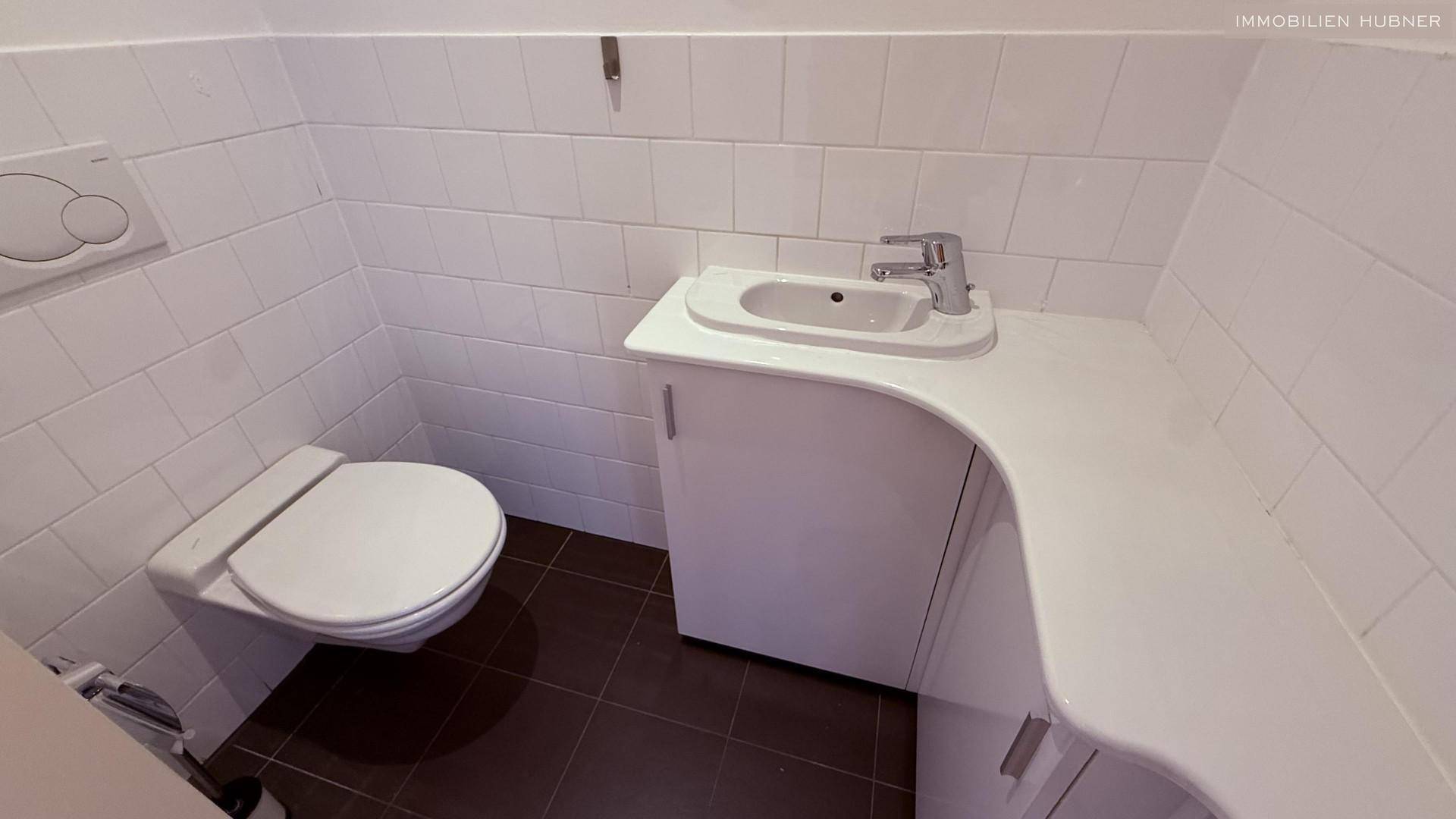 Kleines Gäste-WC mit Wand-WC und modernem Waschbecken.
