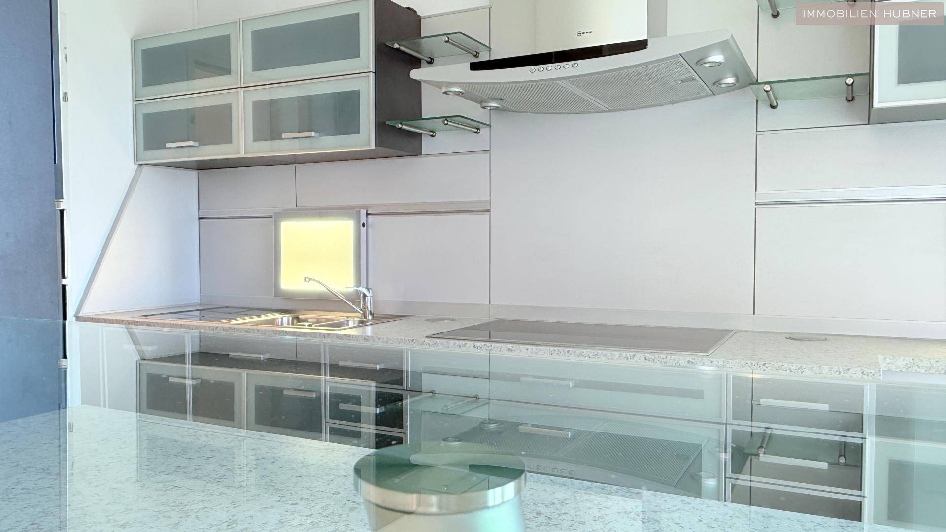 Moderne Küche mit hellen Schränken, integrierten Geräten und glänzenden Arbeitsflächen, ideal zum Kochen.