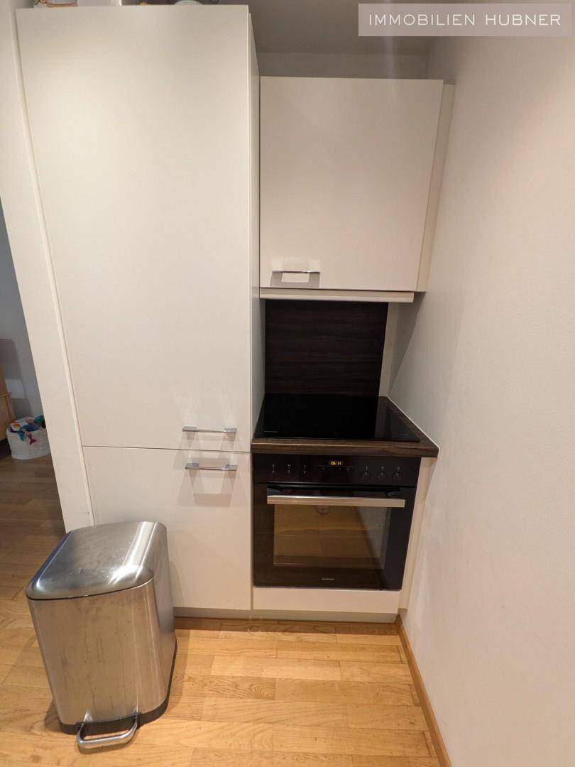 Kompakte Küchenzeile mit integriertem Backofen und Kochfeld, ideal für kleine Wohnungen.