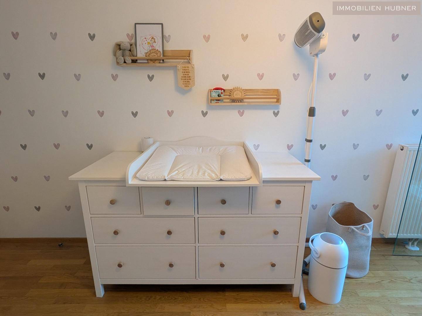 Kinderzimmer mit Wickelkommode und liebevollen Wanddekorationen, ideal für die Kleinsten.