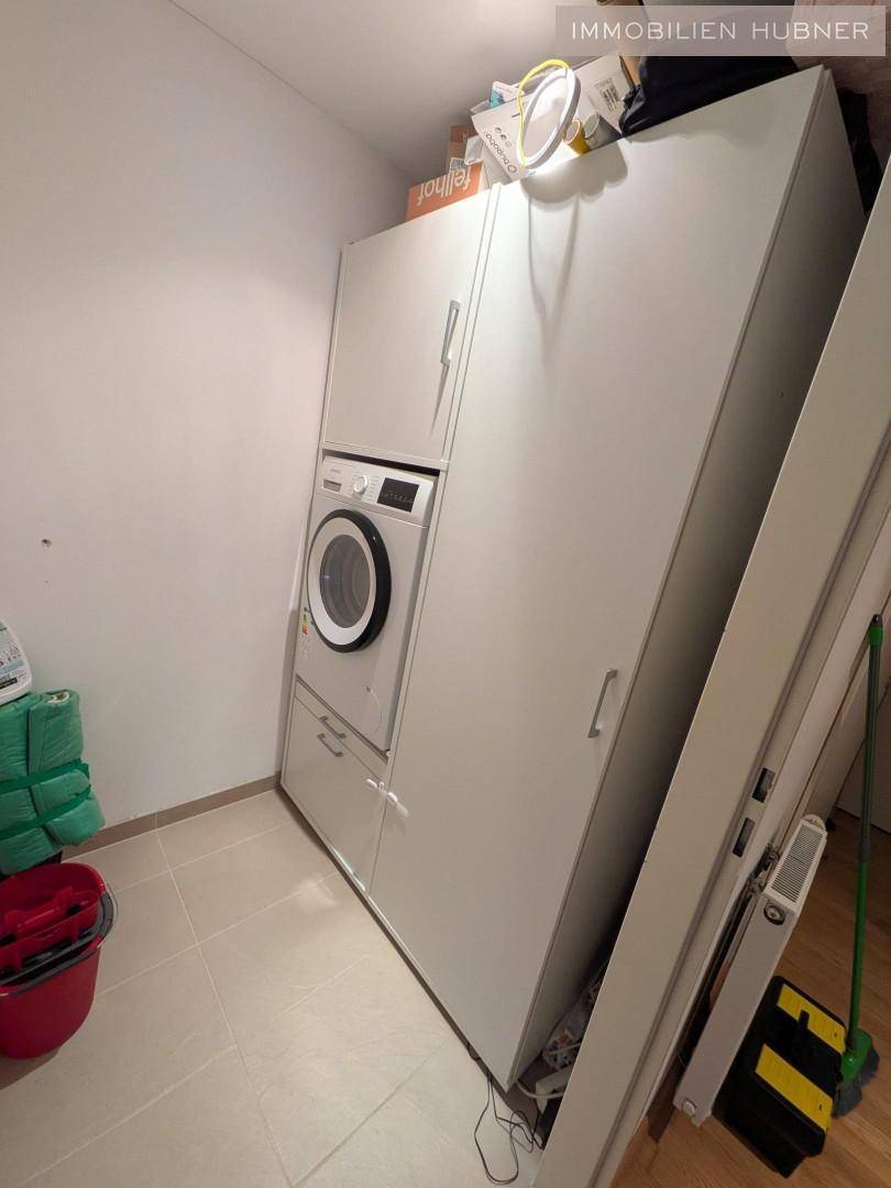 Gut organisierter Hauswirtschaftsraum mit Waschmaschine und Stauraum, ideal für den Alltag.