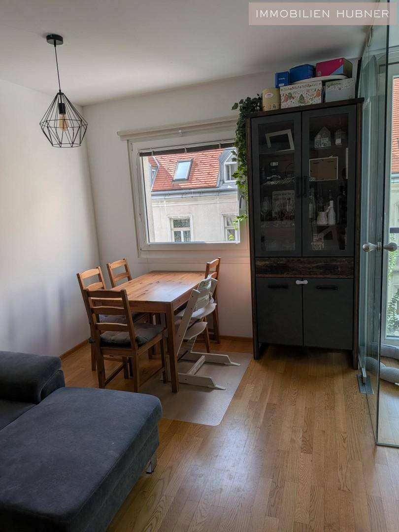 Heller Essbereich mit Holztisch und Stühlen neben einem Fenster, perfekt für Familienmahlzeiten.