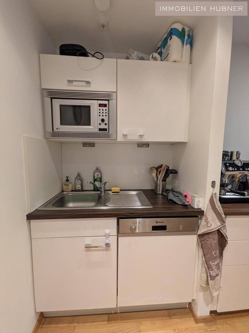 Funktionale Küchenzeile mit Spüle, Mikrowelle und Geschirrspüler, praktisch und platzsparend.