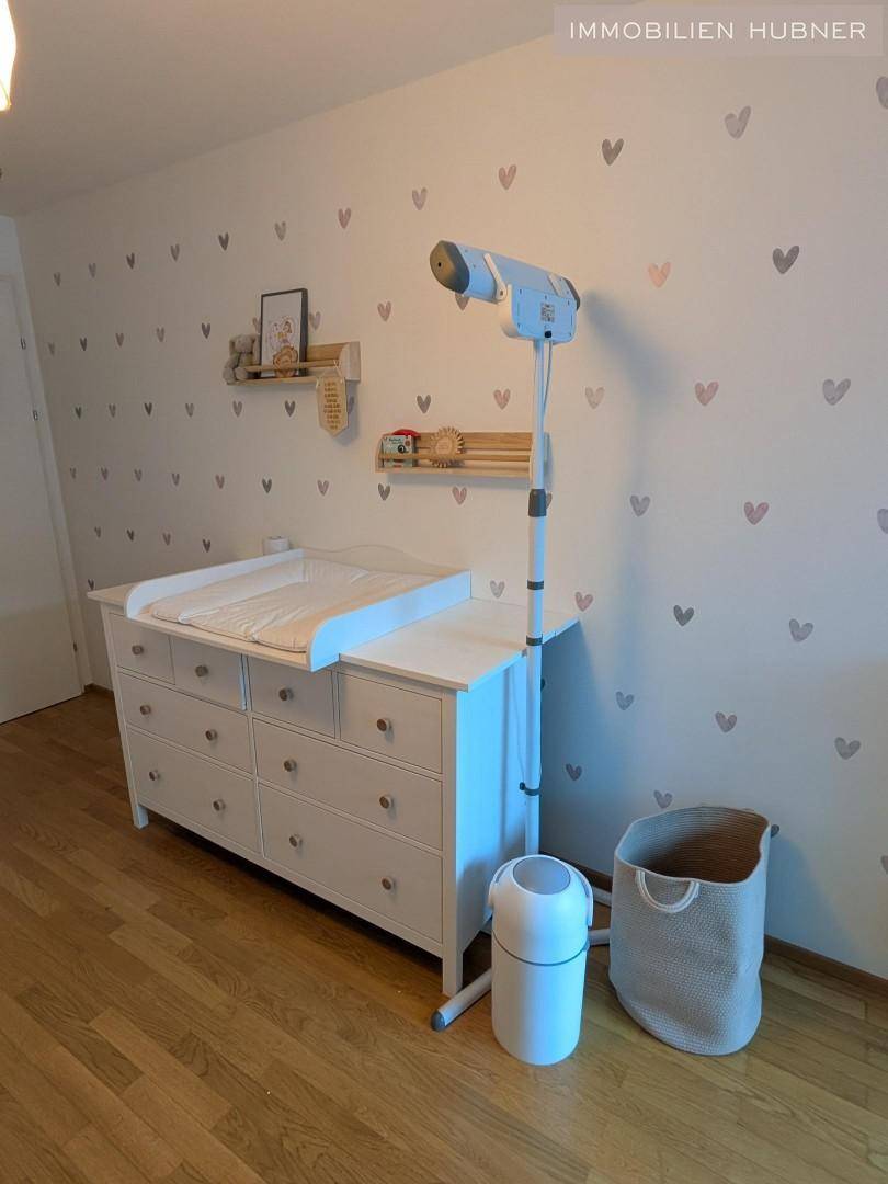 Kinderzimmer mit Wickelkommode und praktischem Heizstrahler, um das Baby warm zu halten.