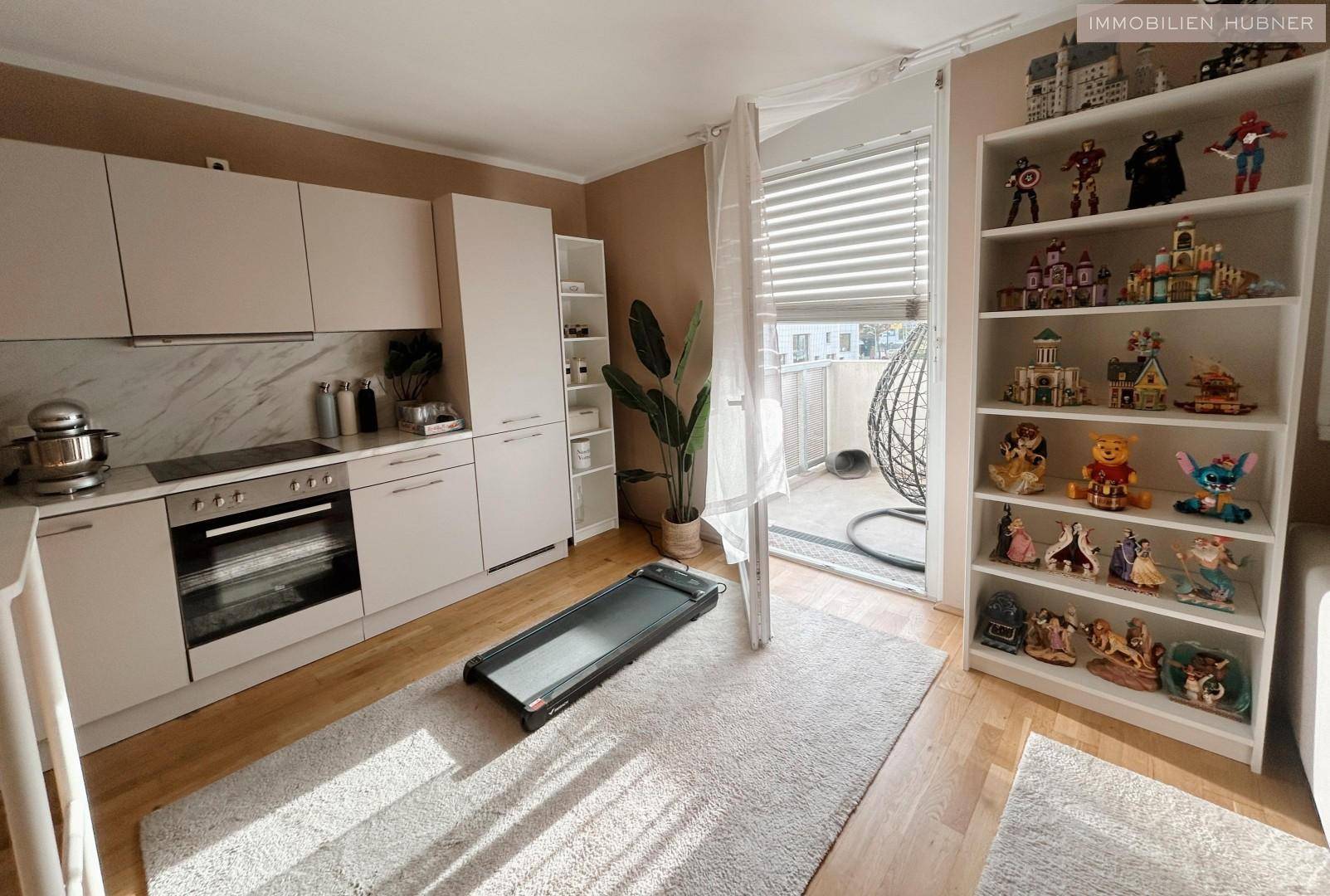 Offener Wohnbereich mit Küchenzeile, Regalen und direktem Zugang zum Balkon für frische Luft.