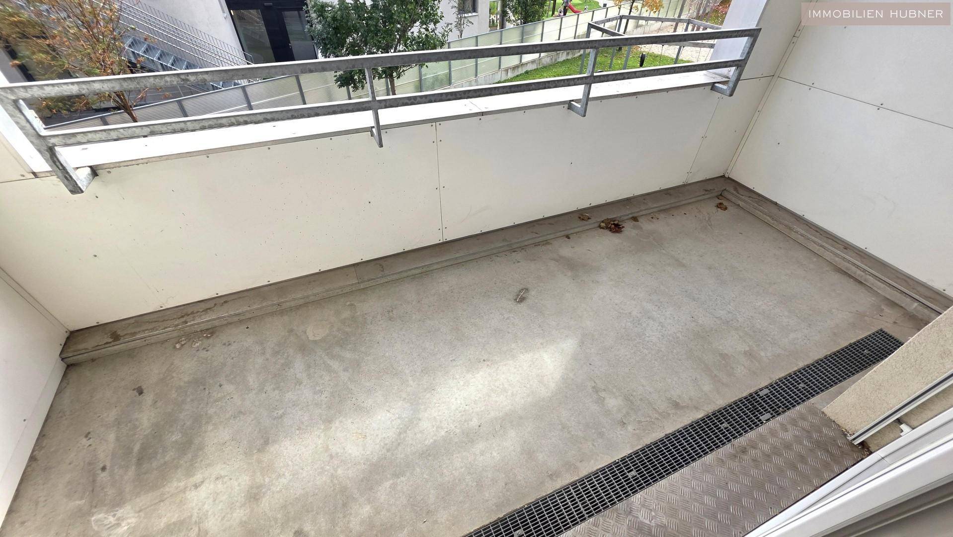 Leerer Balkon mit Betonboden und Metallgeländer, bereit zur individuellen Gestaltung.