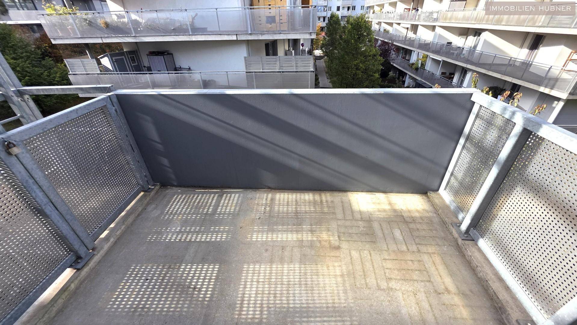 Kleiner Balkon mit Metallgeländer und Blick auf die umliegenden Wohngebäude.