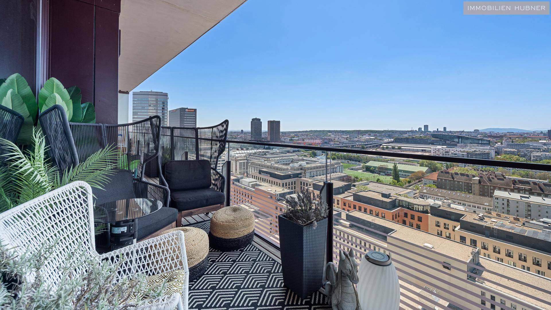 Möblierter Balkon mit gemütlicher Sitzecke und beeindruckendem Panoramablick auf die Stadt.
