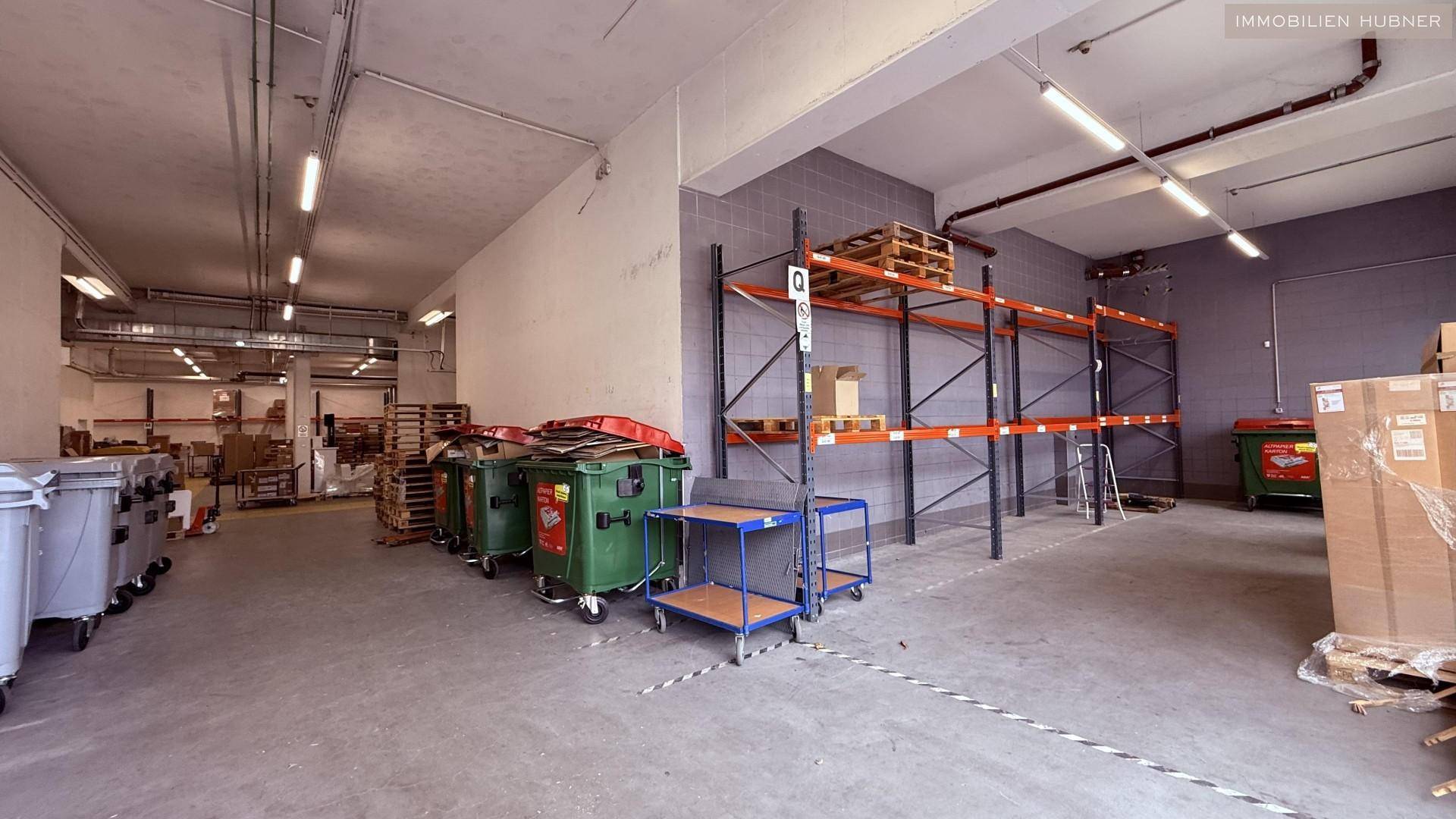 Lagerhalle mit leeren Regalen, Mülltonnen und Paletten, bereit für neue Waren.