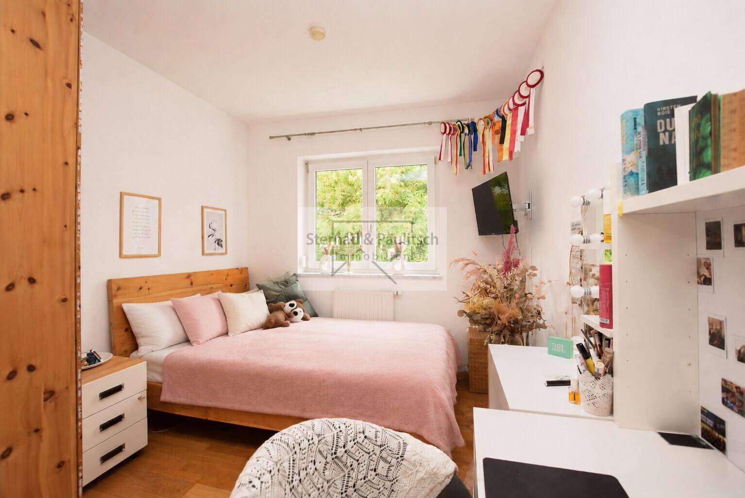 Helles Schlafzimmer mit Einzelbett, Schreibtisch und Fenster, ideal als Kinder- oder Gästezimmer.