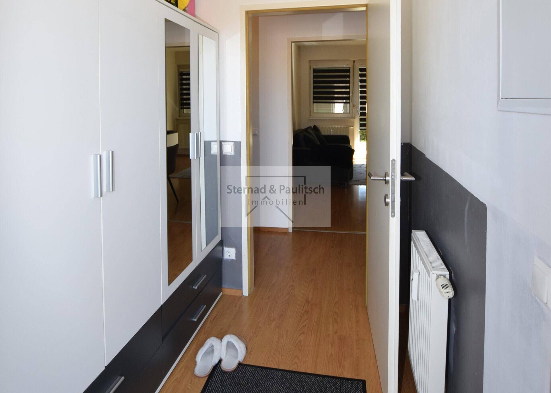 Heller Flur mit Spiegelschrank und Zugang zum Wohnbereich.