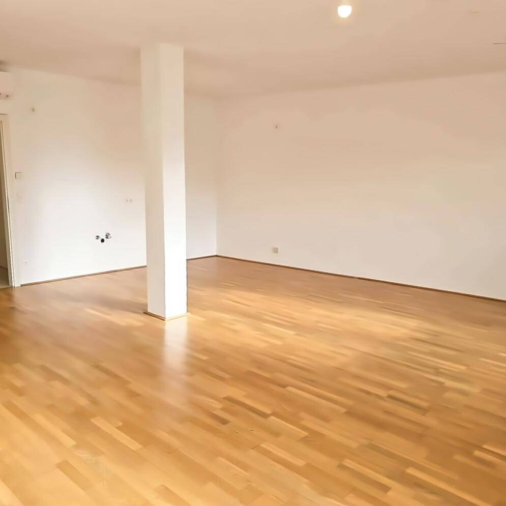 Heller und offener Wohnbereich mit Säule, Parkettboden und vielseitigen Gestaltungsmöglichkeiten.