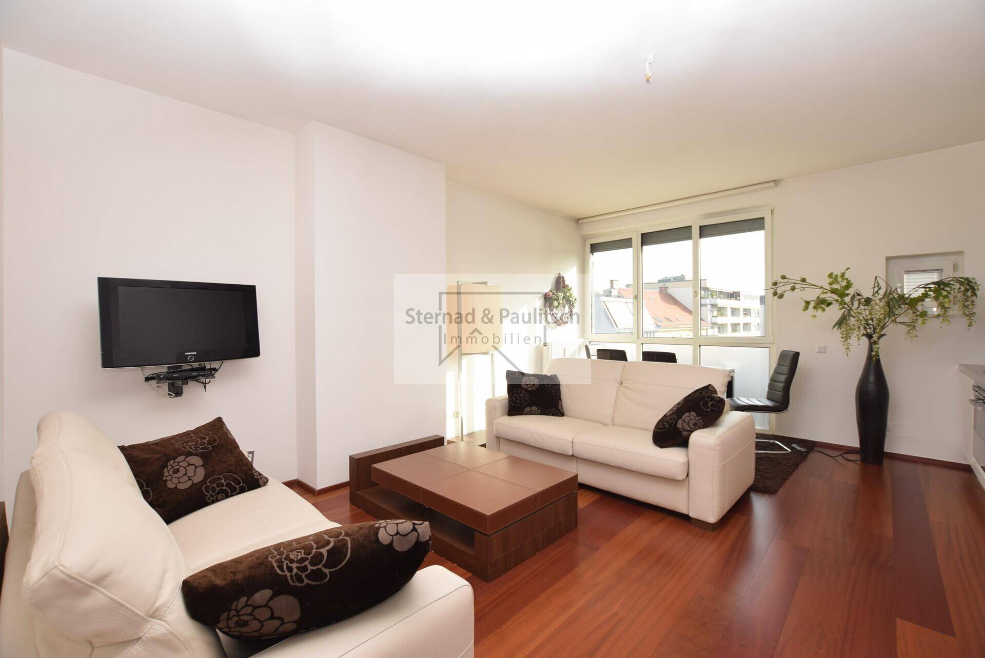 Gemütliches Wohnzimmer mit zwei Sofas, Holzboden und Blick auf den Essbereich.