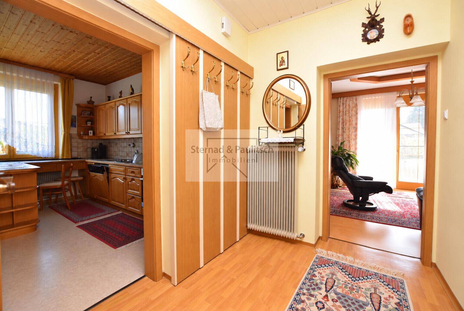 Traditioneller Flur mit Holzvertäfelung, Garderobe und Zugang zu Küche und Wohnzimmer.