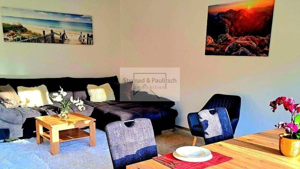 Gemütlicher Wohnbereich mit bequemer Couch, Holztisch und moderner Dekoration.