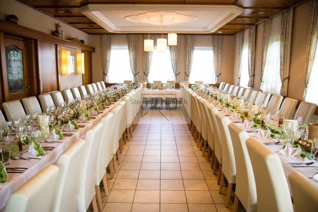Großer, elegant gedeckter Speisesaal mit langen Tischen und traditioneller Holzeinrichtung.