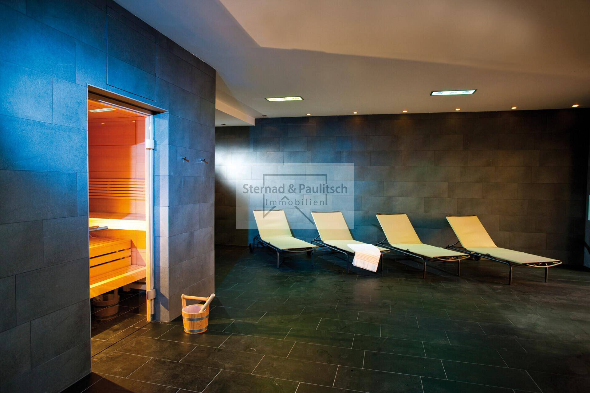 Moderner Wellnessbereich mit Sauna und bequemen Liegen zur Entspannung.