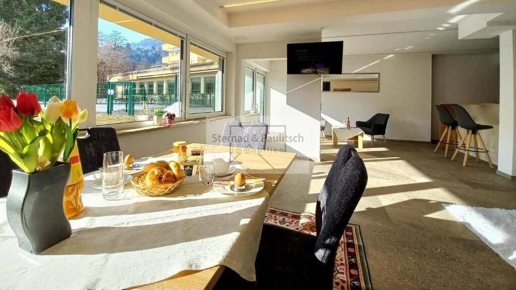 Lichtdurchfluteter Essbereich mit Holztisch und Blick in den offenen Wohnbereich.