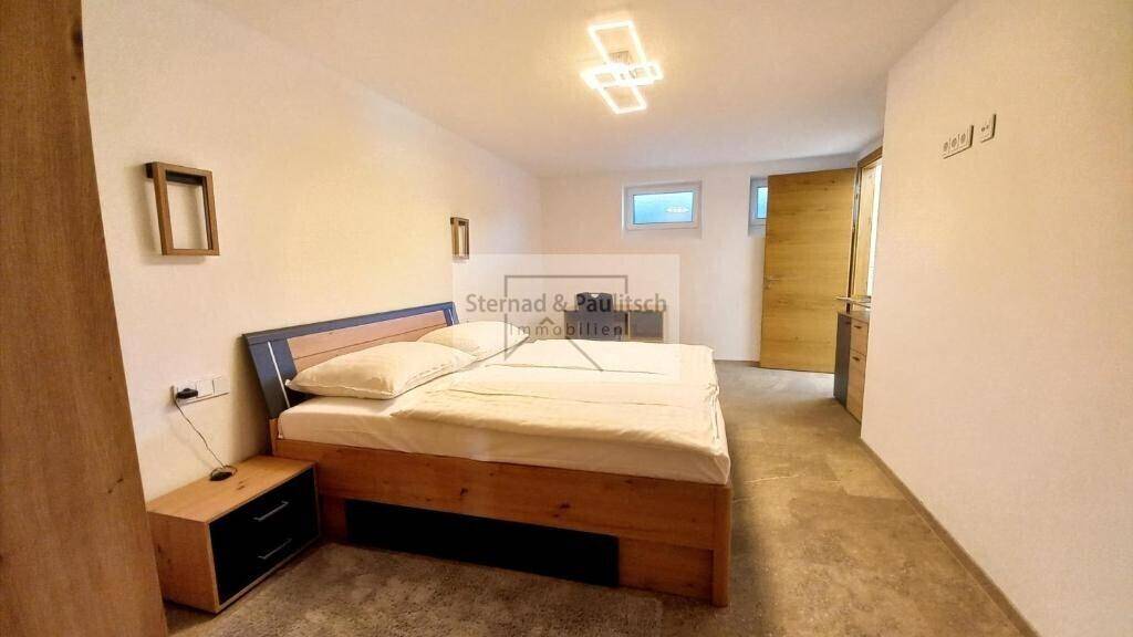 Gemütliches Schlafzimmer mit Doppelbett, Holzelementen und indirekter Deckenbeleuchtung für entspannte Nächte.