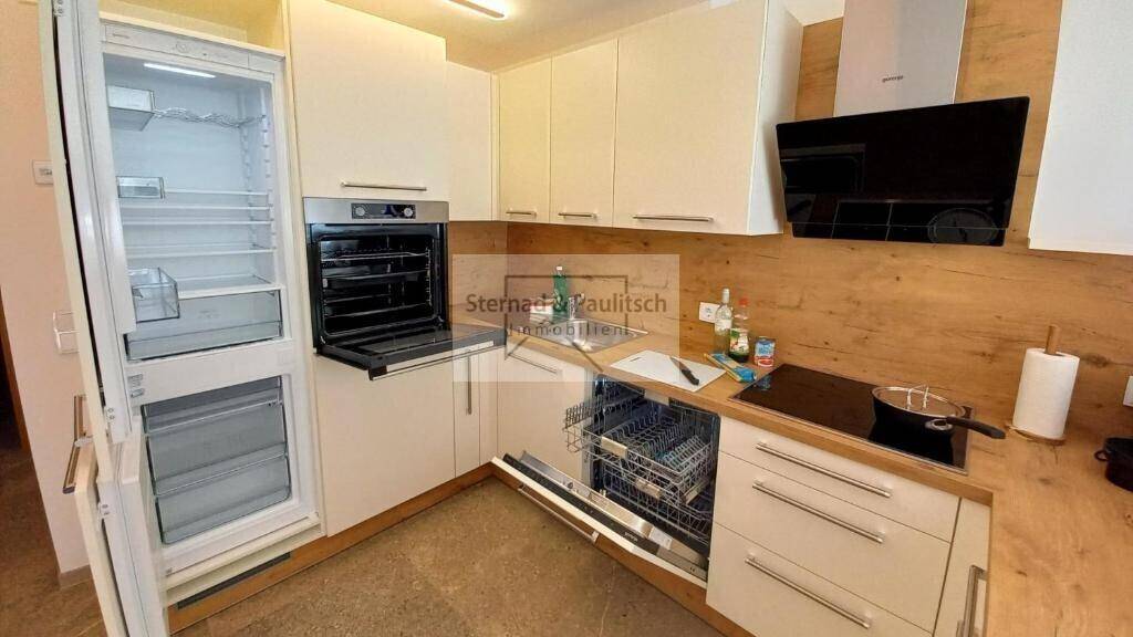 Voll ausgestattete Küche mit modernen Einbaugeräten, Kühlschrank und Geschirrspüler.
