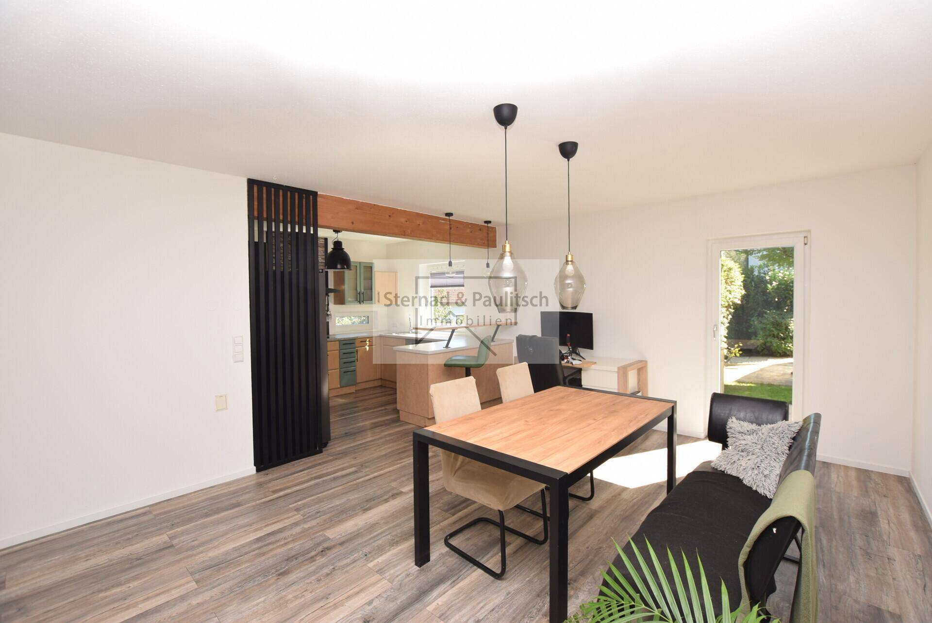 Offener Essbereich mit Holztisch, Laminatboden und Verbindung zur Küche.