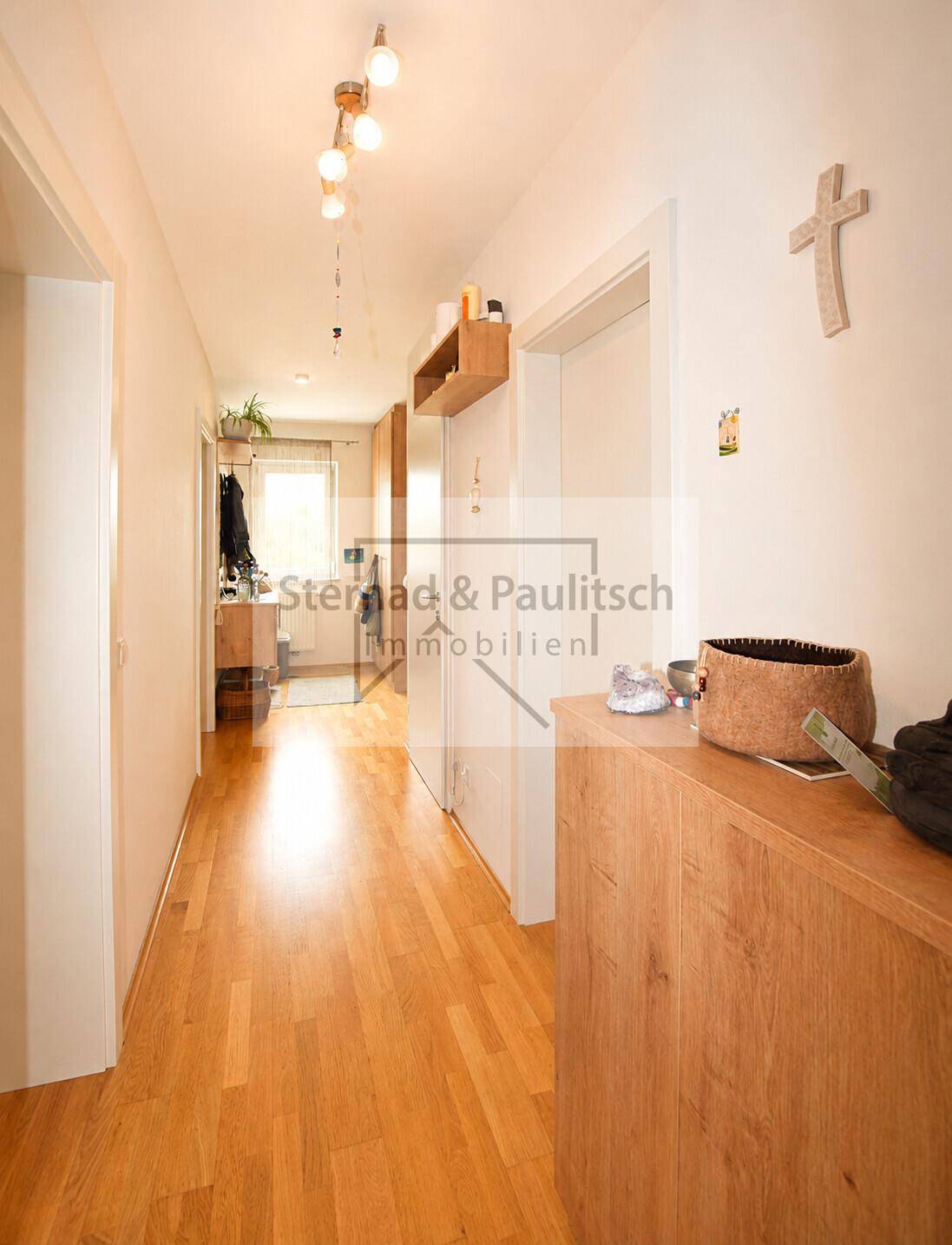 Heller Flur mit Holzboden und Ablagemöglichkeiten, verbindet die Wohnbereiche der Wohnung.