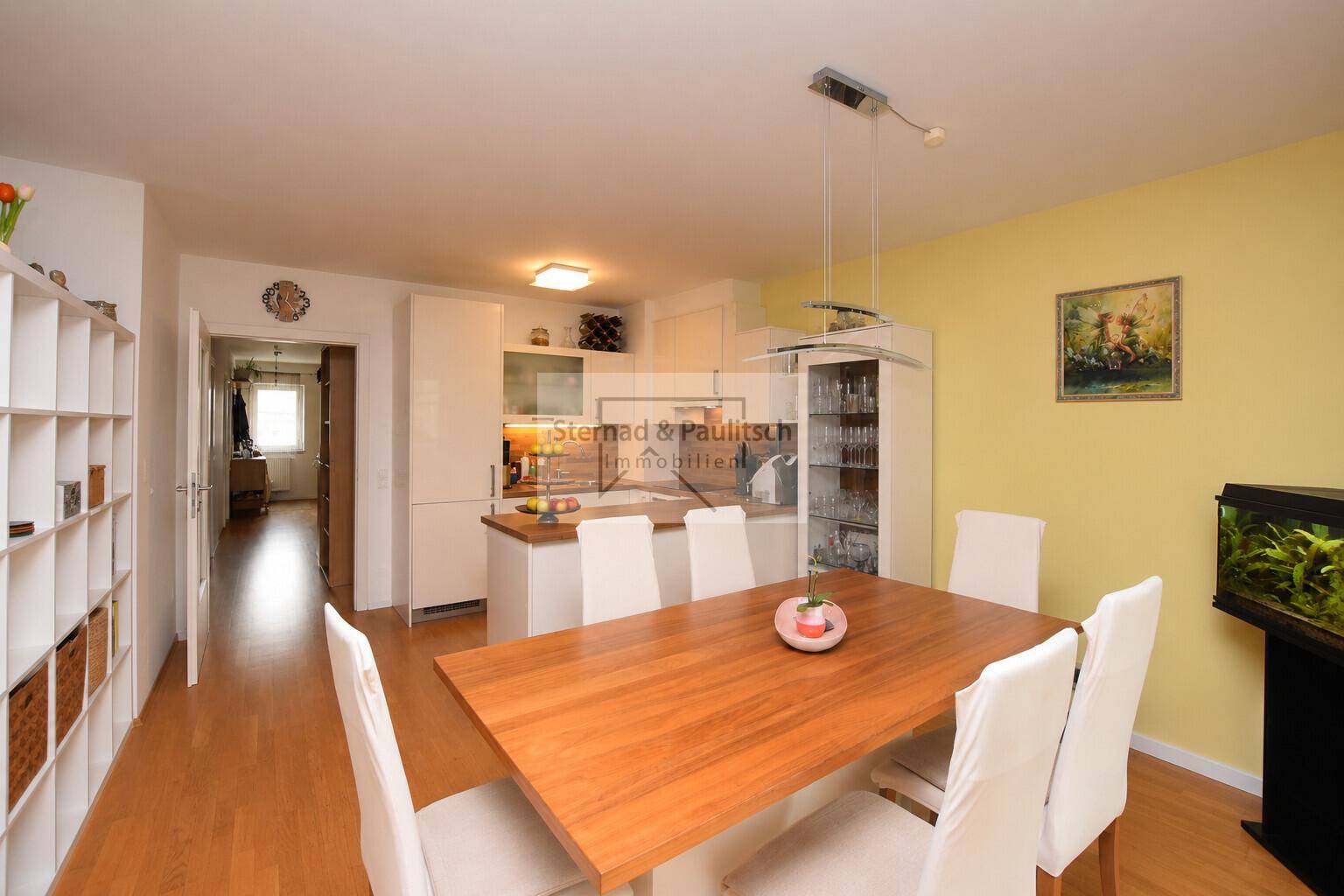 Geräumiger Essbereich mit Holztisch und Blick auf die offene Küche, perfekt für Familienmahlzeiten.