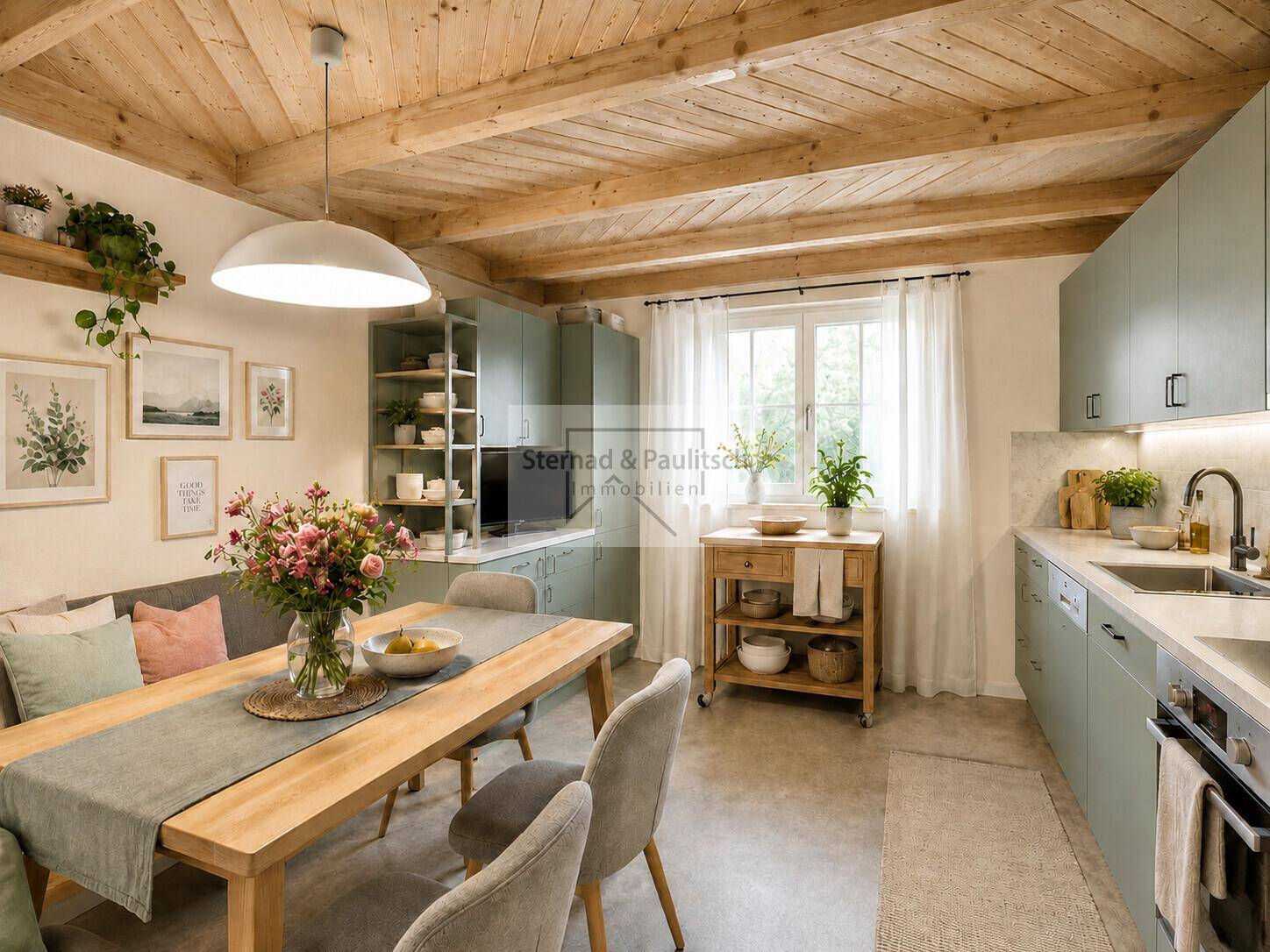 Modernisierte Wohnküche mit hellgrünen Schränken, Holztisch und sichtbaren Deckenbalken.