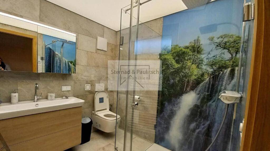 Modernes Badezimmer mit begehbarer Dusche, Wand-WC und Natursteinfliesen, stilvoll und funktional.