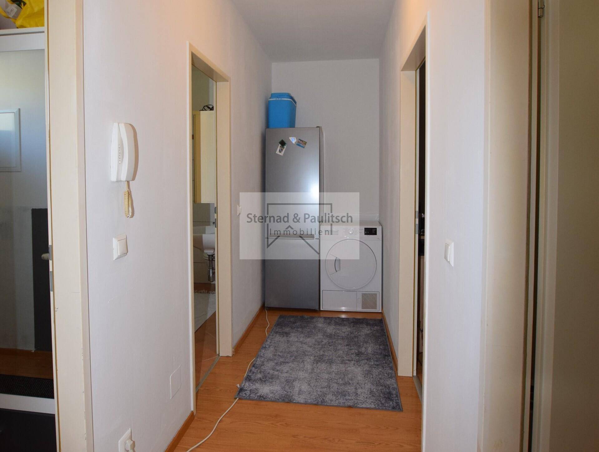 Flur mit praktischer Nische für Kühlschrank und Wäschetrockner.