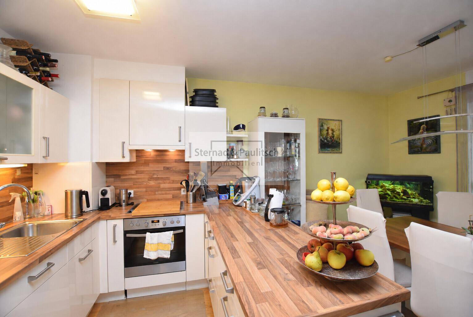Moderne Einbauküche mit Holz-Arbeitsplatten und integrierten Geräten, praktisch und funktional gestaltet.