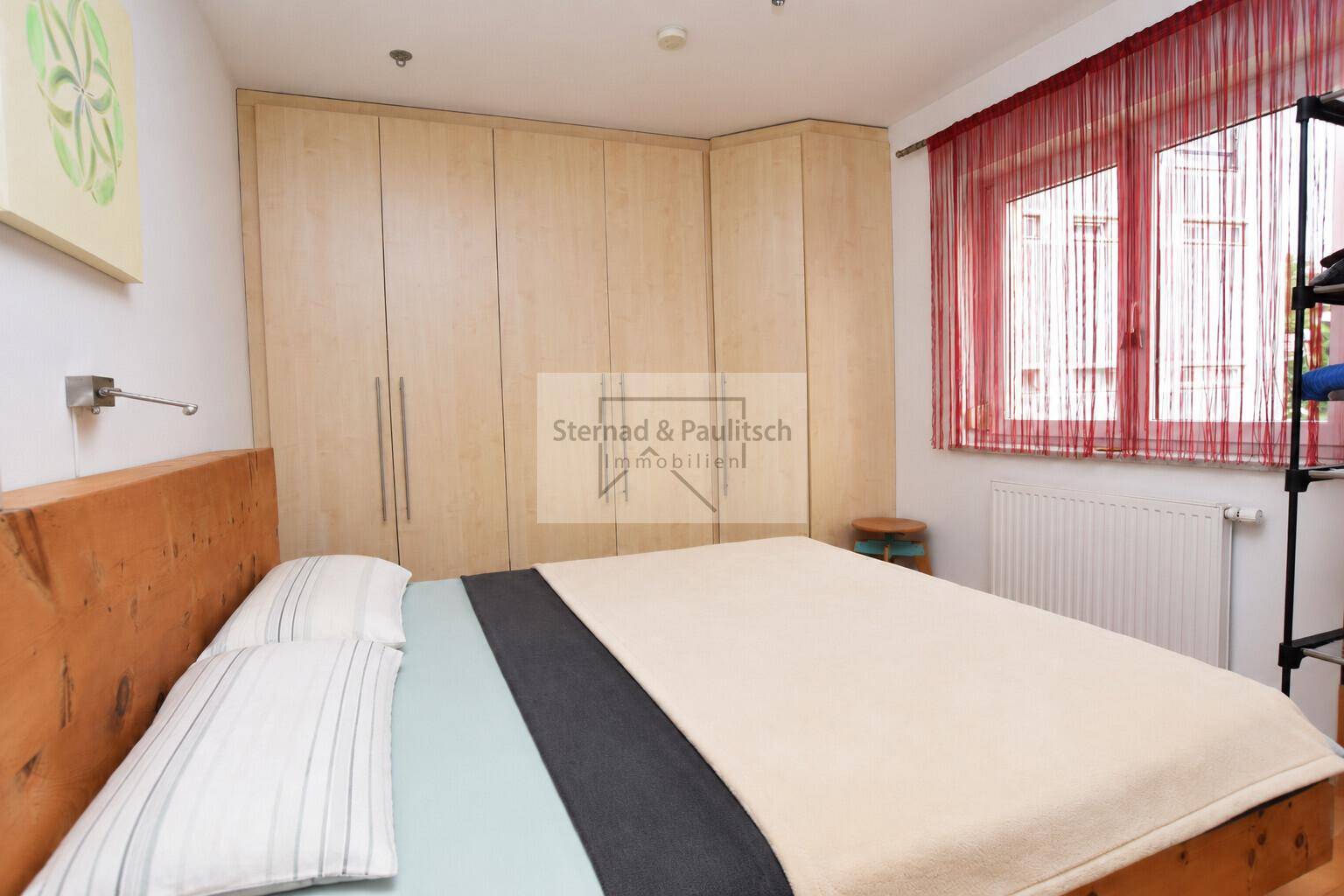 Schlafzimmer mit großem Bett und Einbauschränken, bietet viel Stauraum und eine ruhige Atmosphäre.