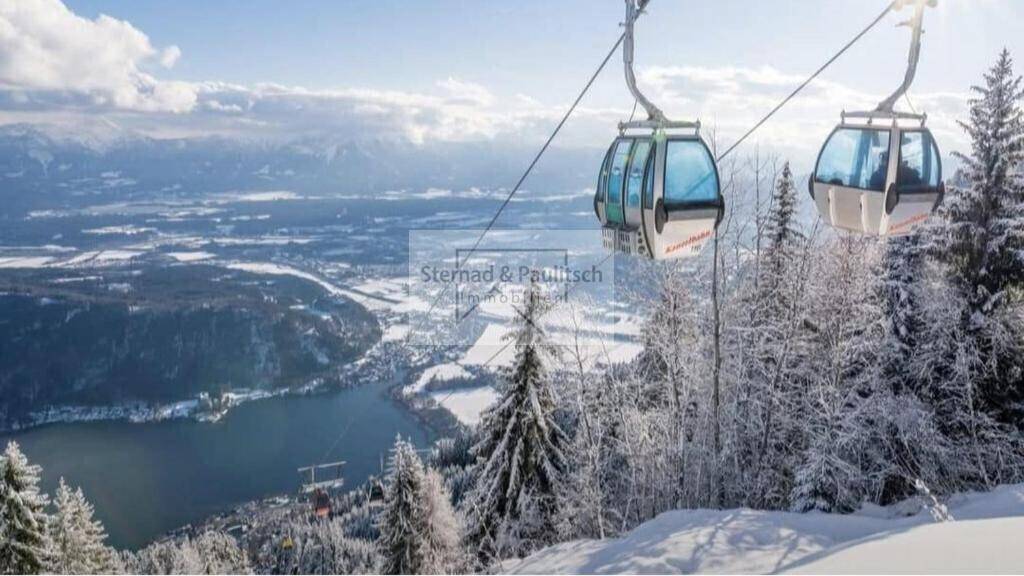 Panoramablick auf verschneite Berge, einen See und Skilifte, der die malerische Umgebung der Immobilie zeigt.