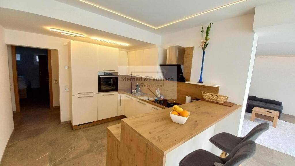 Helle, moderne Einbauküche mit weißen Fronten und integrierter Frühstücksbar.