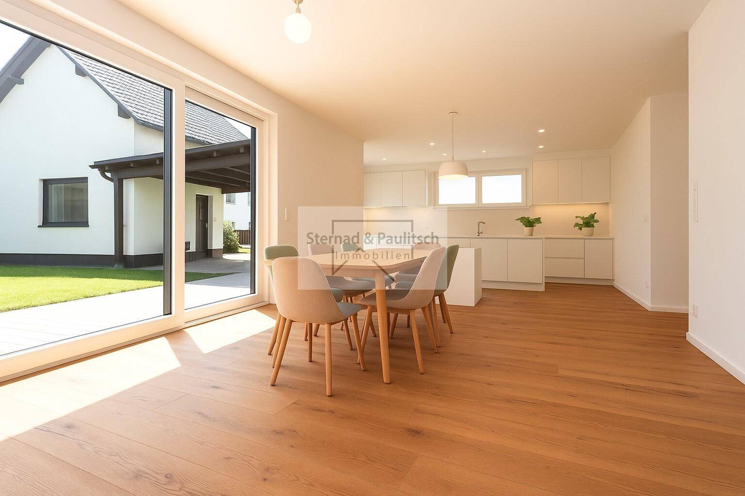 Moderne, helle Küche mit Essbereich, weißen Schränken und Zugang zur Terrasse.