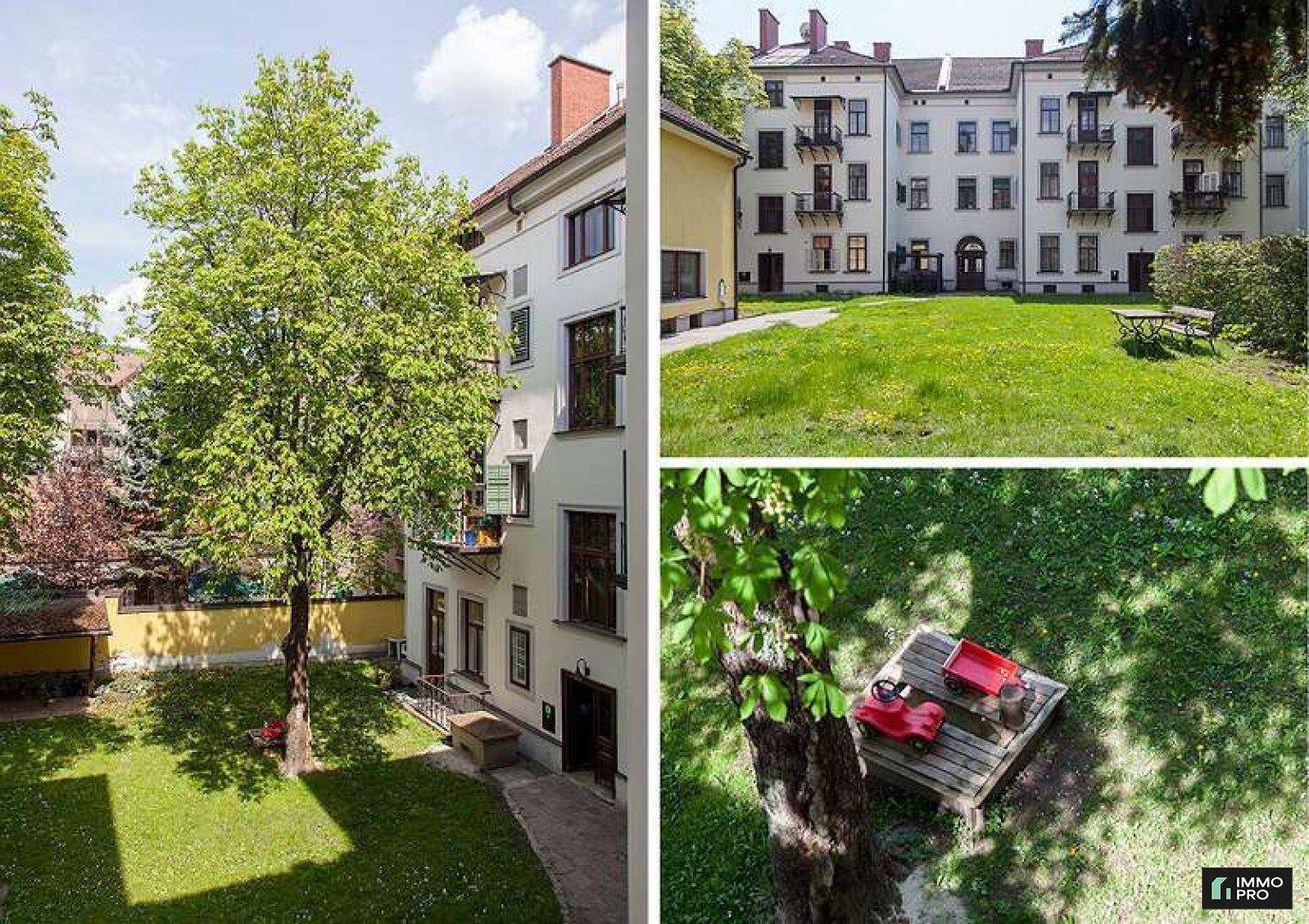 Grüner Innenhof mit Rasenfläche, Bäumen und einem kleinen Spielbereich für Kinder.