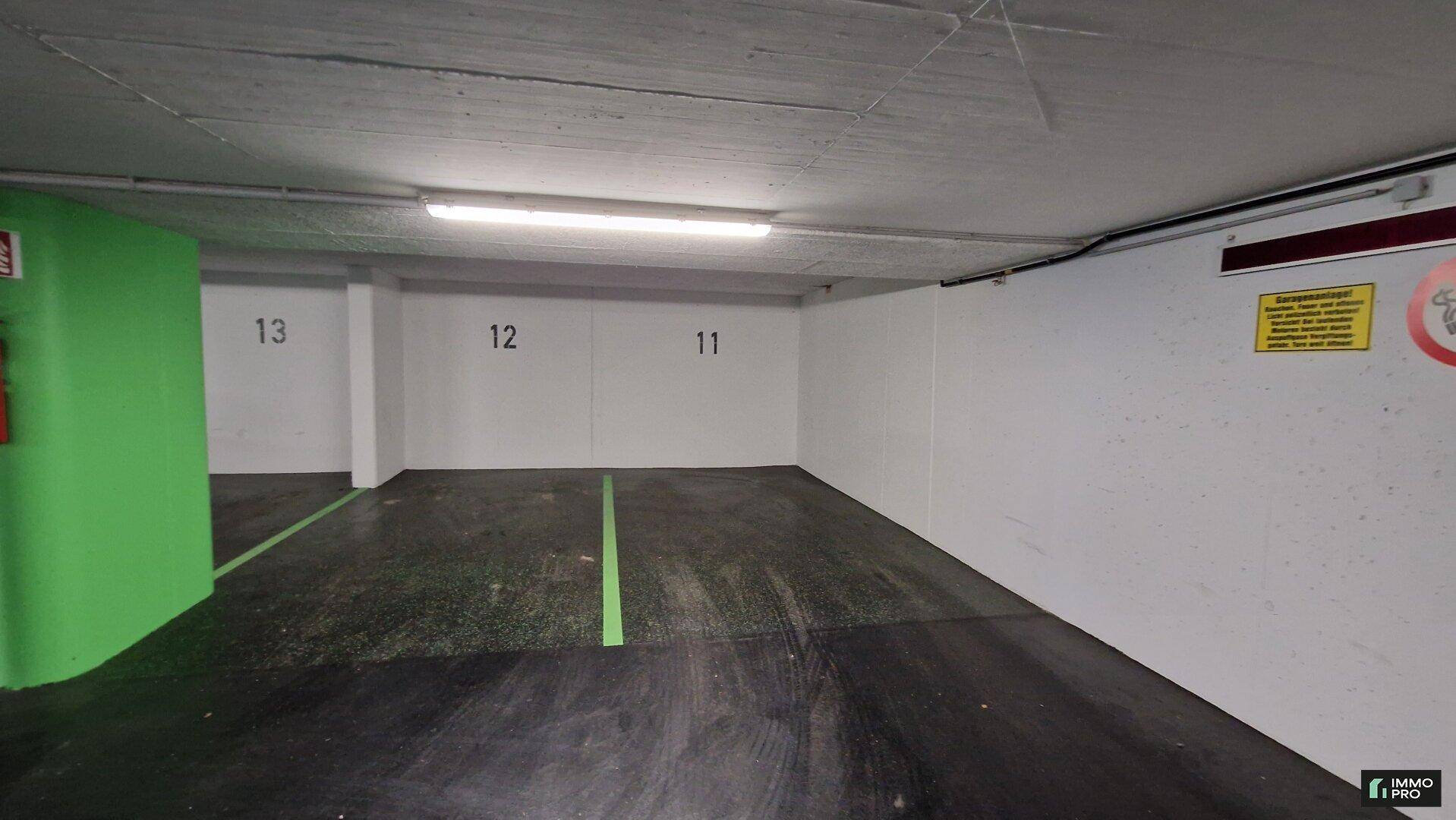 Leerer Stellplatz in einer Tiefgarage mit hellen Wänden und effizienter Beleuchtung.