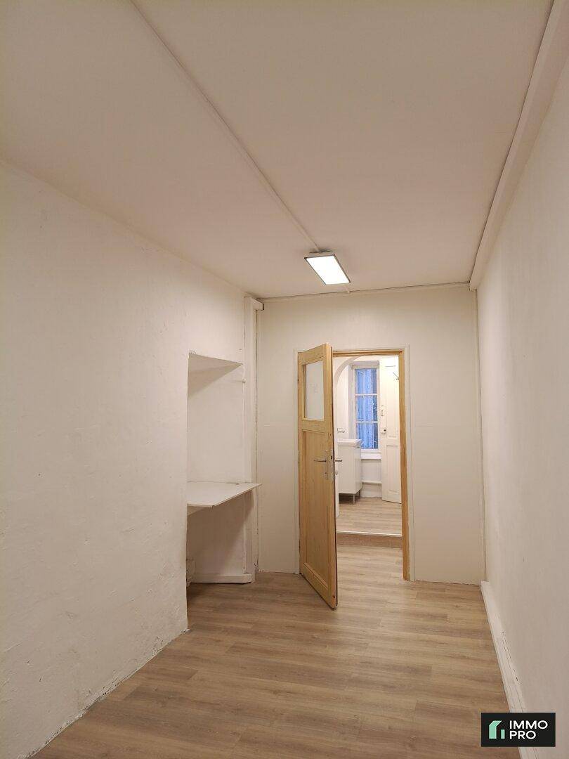 Kleiner Raum mit hellem Laminatboden und einer eingebauten Ablage, ideal als Büro oder Abstellraum.