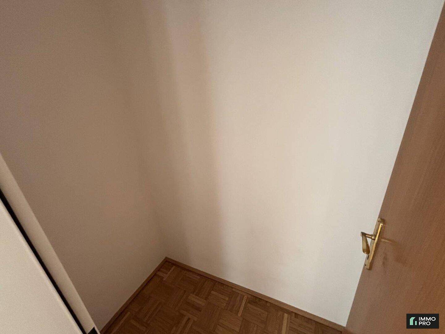 Kleiner Bereich mit Parkettboden und weiß gestrichenen Wänden.