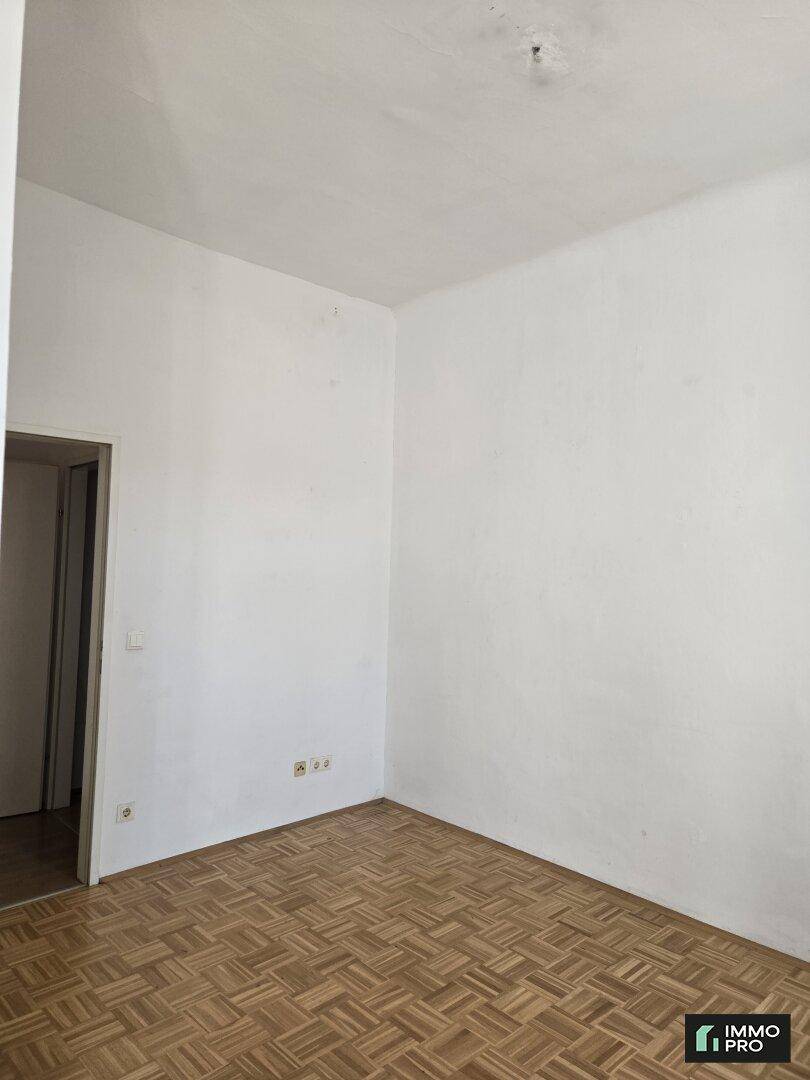Leerer Raum mit Parkettboden und weißen Wänden, bereit zur individuellen Gestaltung.