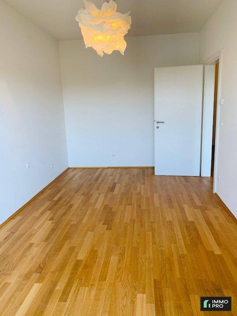 Geräumiges Zimmer mit hellem Parkettboden und weiß gestrichenen Wänden, bereit zur individuellen Gestaltung.