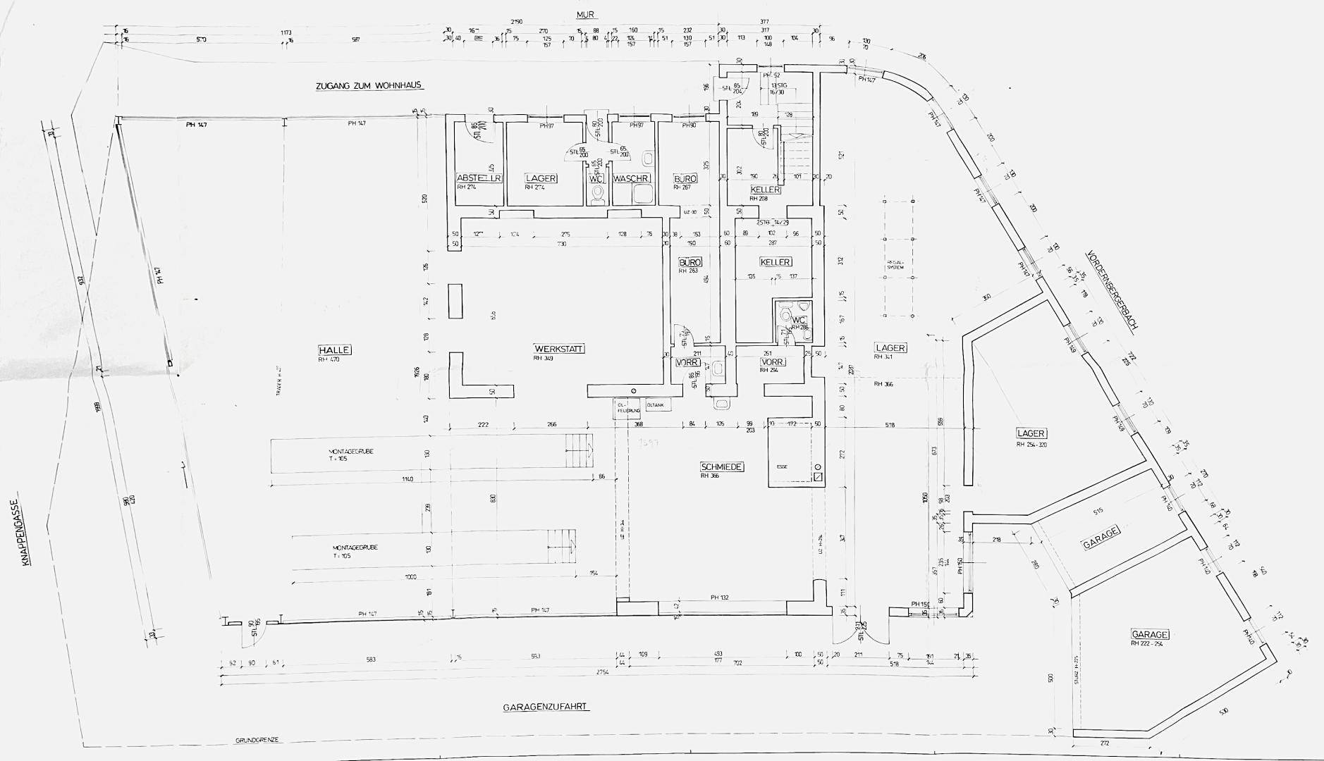 Grundrissplan mit verschiedenen Räumen, Werkstätten, Lagern und mehreren Garagenbereichen sowie einem Keller.