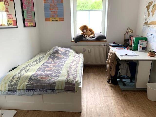 Gemütliches Schlafzimmer mit Einzelbett, Schreibtisch und Fensterblick ins Grüne.