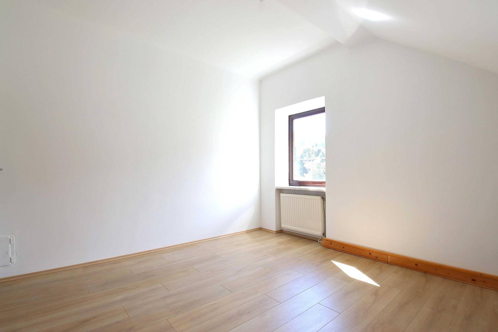 Heller, leerer Raum mit Laminatboden und Dachschräge, ideal für individuelle Gestaltung.